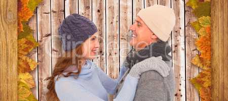 Composite image of happy couple in warm clothing