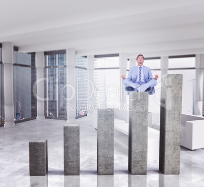 Composite image of calm businessman meditating in lotus pose