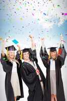 Composite image of three students in graduate robe raising their