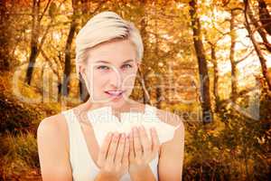 Composite image of sick woman holding tissues looking at camera