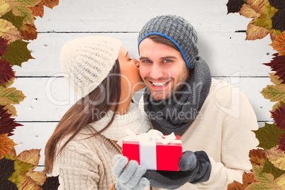 Composite image of winter couple holding gift