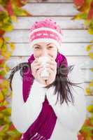 Composite image of winter brunette with coffee