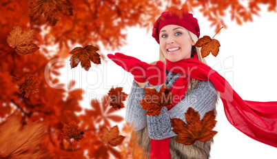 Composite image of blonde in winter clothes with hands out