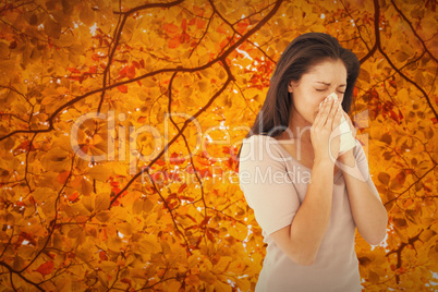 Composite image of sick brunette blowing her nose