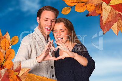 Composite image of happy couple forming heart with hands