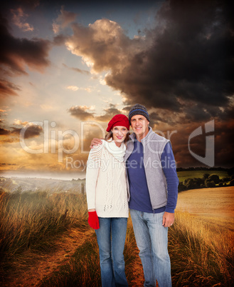 Composite image of happy couple in warm clothing