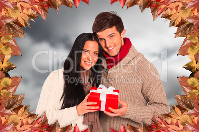 Composite image of young couple holding a gift