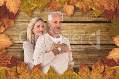 Composite image of cheerful wife embracing husband