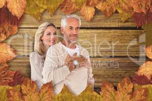 Composite image of cheerful wife embracing husband