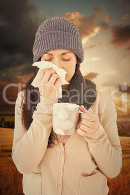 Composite image of sick brunette blowing her nose while holding