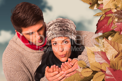 Composite image of young couple blowing over hands