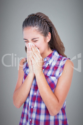 Composite image of sick blonde woman sneezing in a tissue