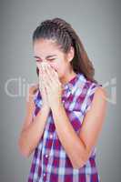 Composite image of sick blonde woman sneezing in a tissue