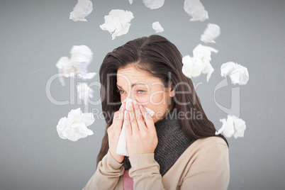 Composite image of sick brunette blowing her nose