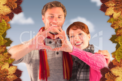 Composite image of couple making a heart shape