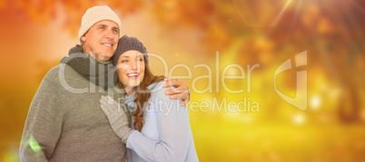 Composite image of couple in warm clothing embracing