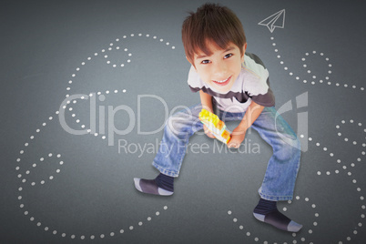 Composite image of cute boy sitting with building blocks