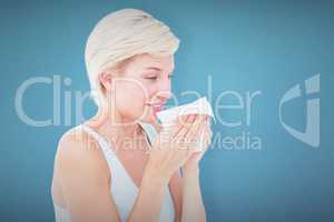 Composite image of sick blonde sneezing