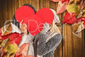 Composite image of couple behind red heart