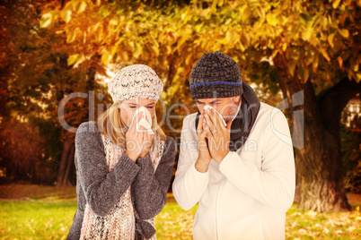 Composite image of couple sneezing in tissue