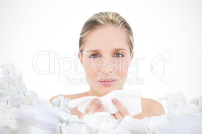 Composite image of unhappy fresh blonde woman sneezing