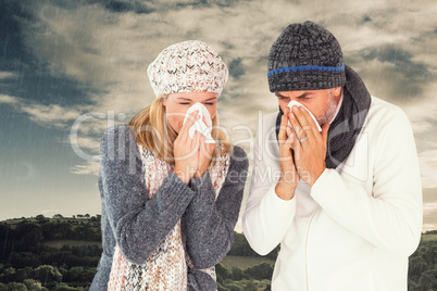 Composite image of couple sneezing in tissue