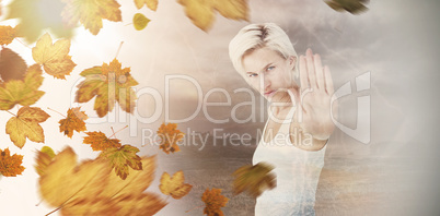 Composite image of angry pretty blonde showing her hand