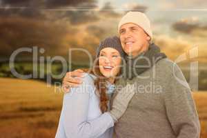 Composite image of couple in warm clothing embracing