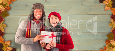 Composite image of couple smiling and holding gift