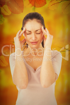 Composite image of brunette suffering from migraine