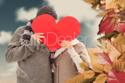 Composite image of happy mature couple in winter clothes holding