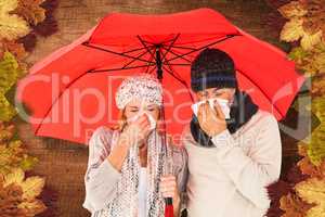 Composite image of ill couple sneezing in tissue while standing