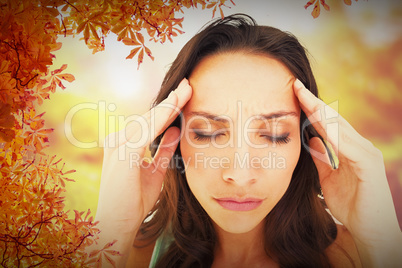 Composite image of pretty brunette with a headache