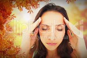 Composite image of pretty brunette with a headache
