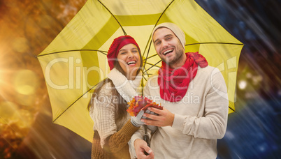Composite image of autumn couple holding umbrella