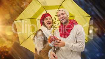 Composite image of autumn couple holding umbrella