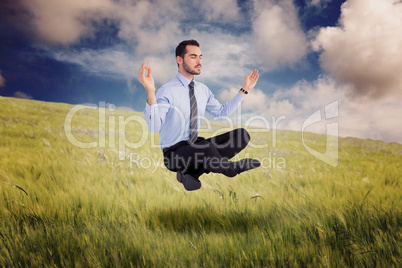 Composite image of relaxed businessman sitting in lotus pose
