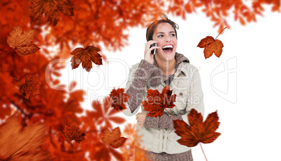 Composite image of laughing cute brunette in winter fashion phon