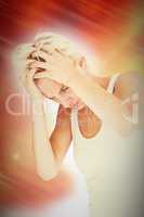 Composite image of sad blonde woman with head pain holding her h