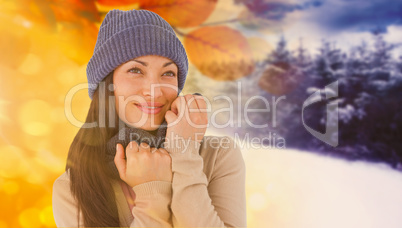 Composite image of attractive brunette looking up wearing warm c