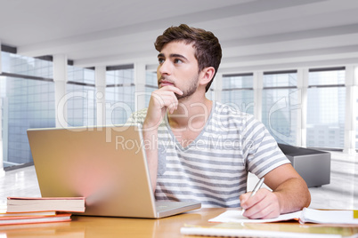 Composite image of student studying in the library with laptop