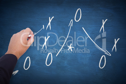 Composite image of hand of a businessman writing with a chalk