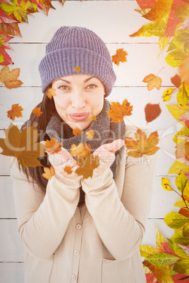 Composite image of beautiful brunette smiling at camera and blow