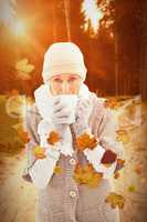 Composite image of woman in warm clothing holding mugs