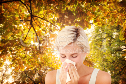 Composite image of sick woman blowing her nose