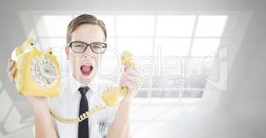 Composite image of geeky businessman shouting at retro phone