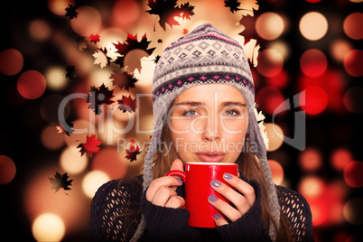 Composite image of beautiful woman in warm clothing drinking cof