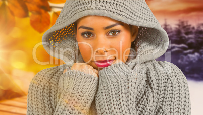 Composite image of pretty girl in winter jumper looking at camer