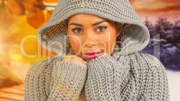 Composite image of pretty girl in winter jumper looking at camer