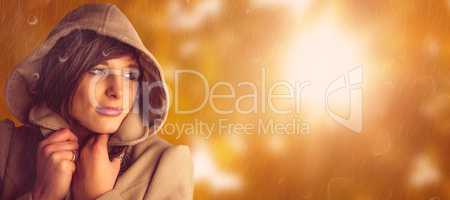 Composite image of beautiful woman wearing winter coat looking a